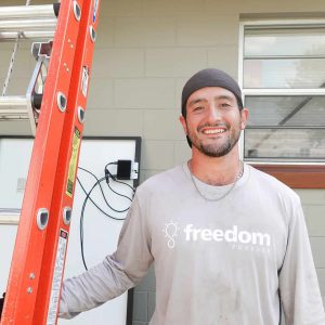 Freedom Forever employee holding ladder before panel installation